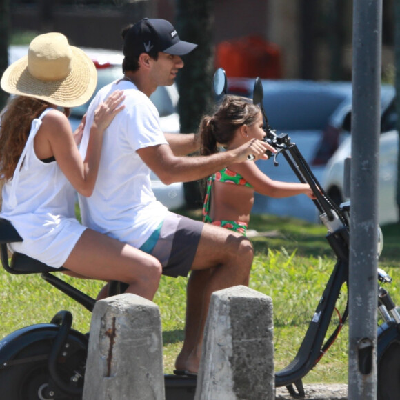 Deborah Secco, o marido, Hugo Moura, e a filha, Maria Flor, foram fotografados em passeio de bicicleta após praia