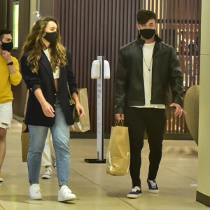 Rafa Kalimann e Daniel Caon apostam em tênis, calça, blusa branca e casaco preto para ida ao shopping