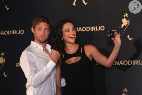 O campeão de Fórmula 1 Jenson Button faz charme ao posar ao lado de Débora Nascimento