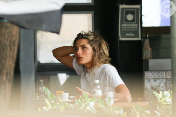 Sasha Meneghel arruma cabelo enquanto conversa com amiga em restaurante