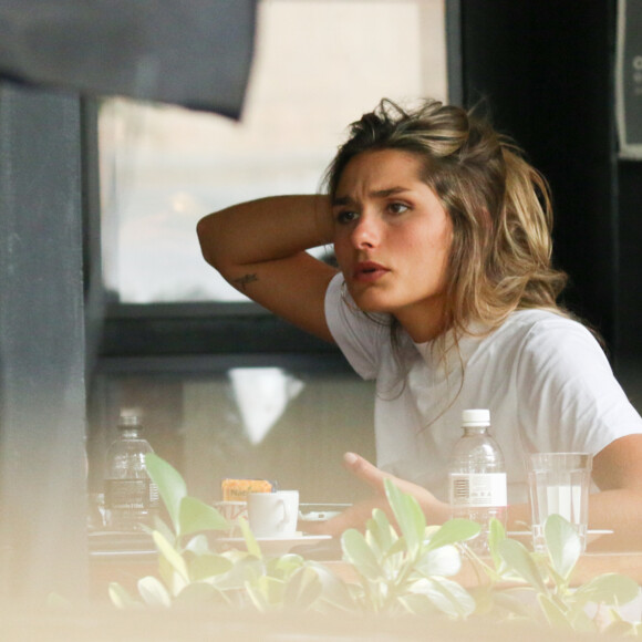 Sasha Meneghel arruma cabelo enquanto conversa com amiga em restaurante