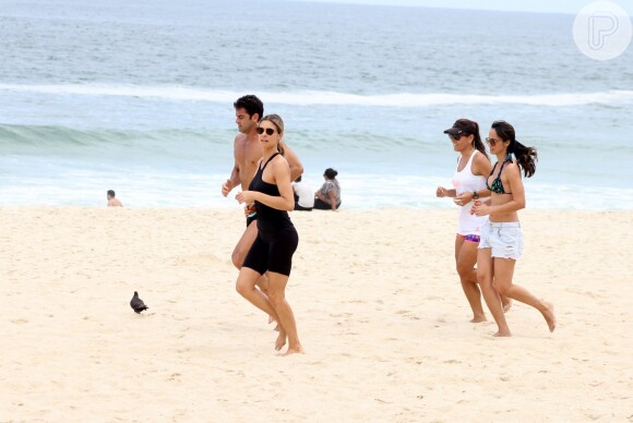 Fernanda Lima optou por uma roupa toda preta para correr na praia
