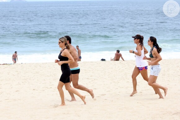 Fernanda Lima mostrou a boa forma durante corrida na praia do Leblon