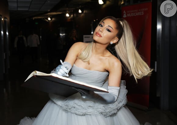 Ariana Grande usou vestido de noiva justo, feito em charmeuse de seda na cor branco-lírio acentuado e um decote esculpido, sem alças.