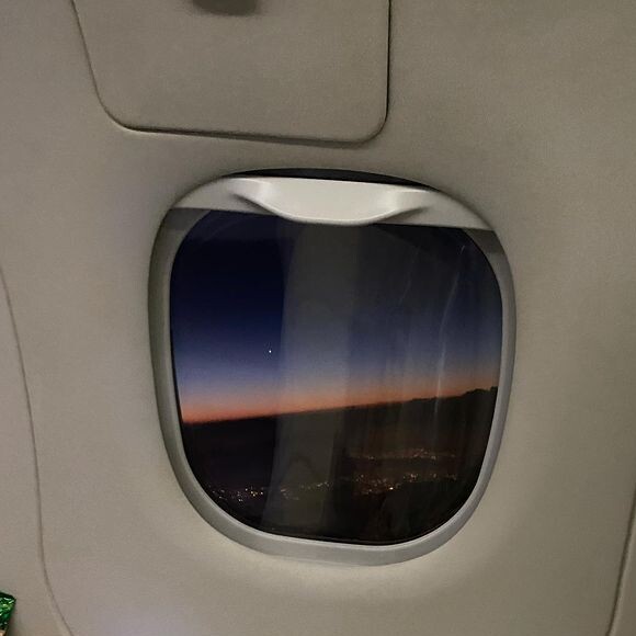 Outra foto, mais conceitual, mostra o céu noturno visto por uma janela de avião