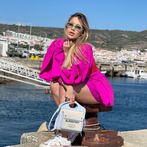 Virgínia posa com look pink próxima ao rio Tejo, em Portugal