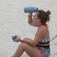 Larissa Manoela se refresca após aula de futevôlei em praia da Barra da Tijuca