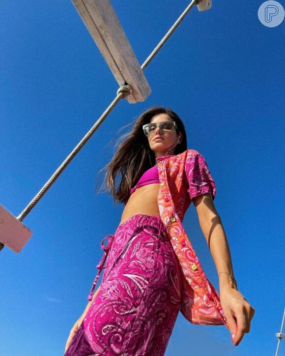 Moda praia: Camila Queiroz elegeu biquíni rosa cortininha e completou o look com uma saída de praia estampada