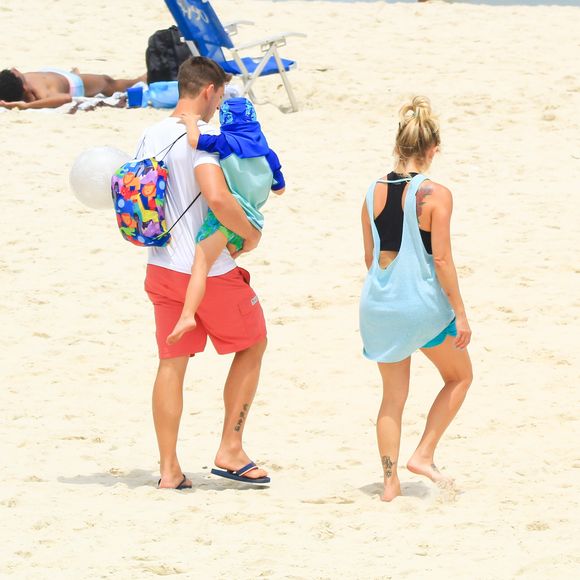 Karina Bacchi foi vista deixando a praia com marido e o filho