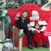 Klebber Toledo senta na cadeira do Papai Noel durante passeio em shopping