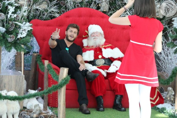 Klebber Toledo senta na cadeira do Papai Noel durante passeio em shopping