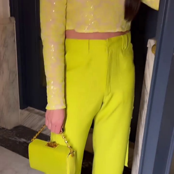 Cropped de Andressa Suita, em tule bordado de micro paetês, é amarelo e possui mangas longas, decote redondo nas costas