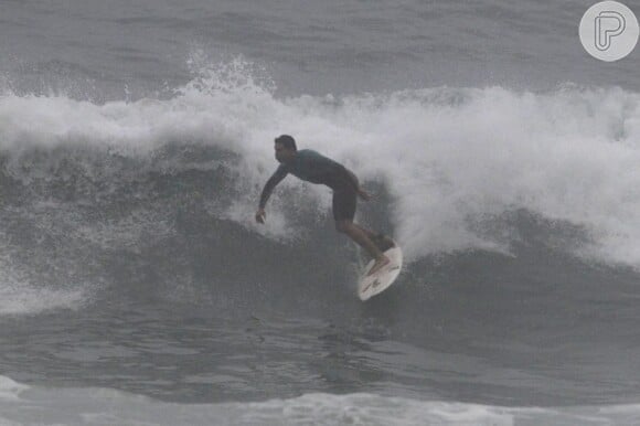 Mesmo sob um dia cinzento, Cauã Reymond surfou no Rio de Janeiro