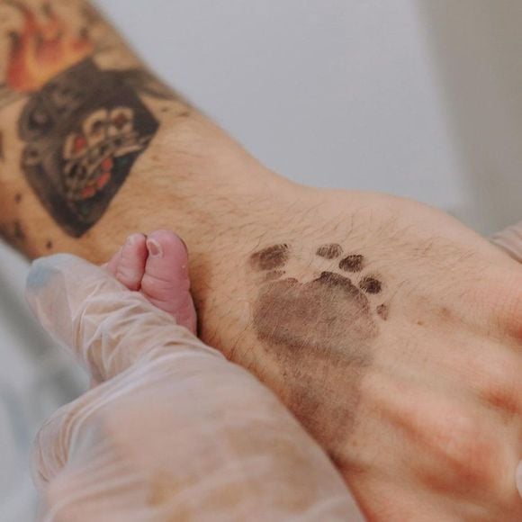 Biel carimba pés da filha para tatuagem