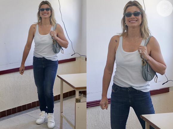 Camiseta branca no estilo regata foi usada por Flávia Alessandra com uma calça jeans skinny e tênis