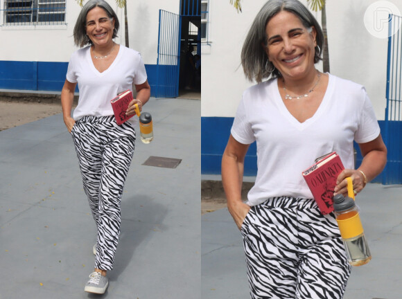 Camiseta branca com gola V foi usada por Gloria Pires com calça reta com estampa de zebra em fundo branco e tênis