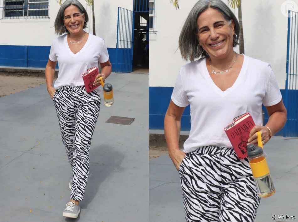 Camiseta branca com gola V foi usada por Gloria Pires com calça reta com estampa de zebra em fundo branco e tênis