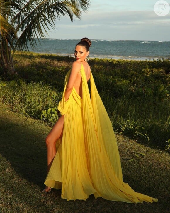 Look amarelo para convidada de casamento: o vestido usado por Cati Lauser tem costas à mostra