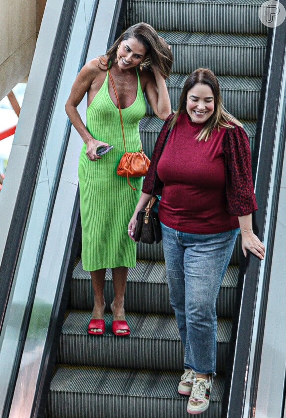 Deborah Secco combinou vestido midi verde com tamancos vermelhos e bolsa laranja