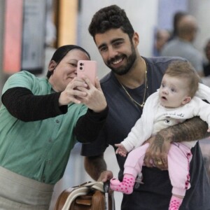 Pedro Scooby posou para fotos com fãs com a filha no colo