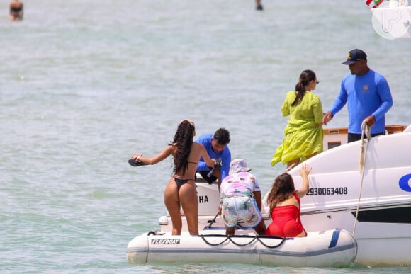 A modelo Juliana Nalú recebe ajuda para deixar bote e embarcar em lancha na Bahia