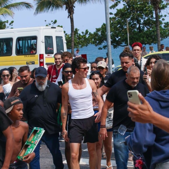 Com sorrisão no rosto, Shawn Mendes vai à praia de Ipanema e é cercado por uma multidão de fãs. Veja fotos!