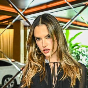 Alessandra Ambrosio posa com acessórios prata e look preto transparente