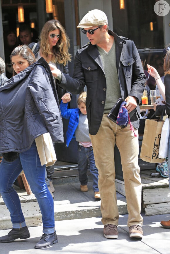Tom Brady, marido de Gisele Bündchen, usa uma jaqueta e tenta esconder a menina dos flashes dos fotógrafos
