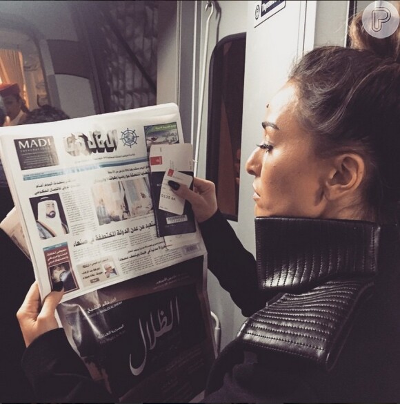 Em uma foto, Sabrina Sato aparece lendo jornal de Dubai