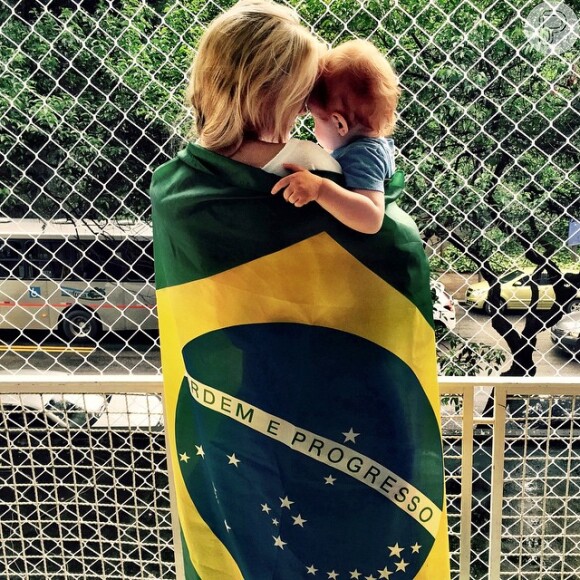 Carol Trentini publicou foto ao lado do filho, enrolada na bandeira nacional: 'A gente se importa'