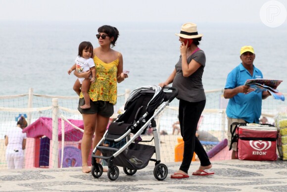Grávida, Carolina Ferraz empurra carrinho de bebê da amiga durante caminhada na orla da praia do Leblon, no Rio, neste domingo 15 de março de 2015