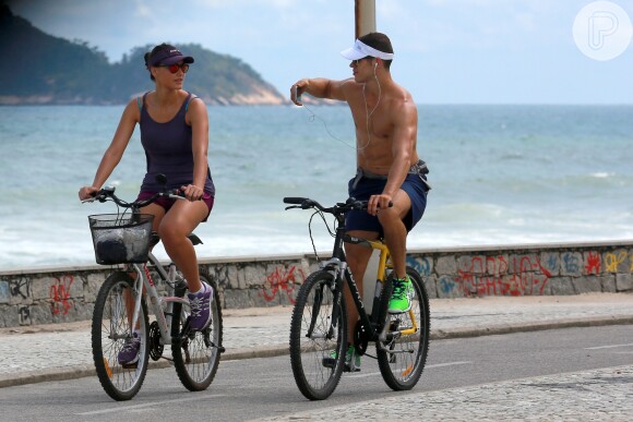 Débora Nascimento anda de bicicelta com o noivo, José Loreto, na orla da Praia da Macumba, no Rio de Janeiro