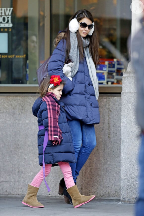 Suri Cruise é flagrada com a mãe Katie Holmes usando um casaco de frio e uma bota de camursa