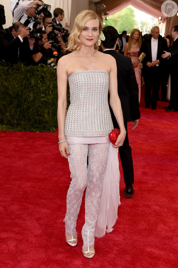 Diane Kruger apostou em um conjunto tomara que caia e calça da grife Chanel Couture coleção 2011 e bolsa de coração. Chegou com o namorado, o ator Joshua Jackson
