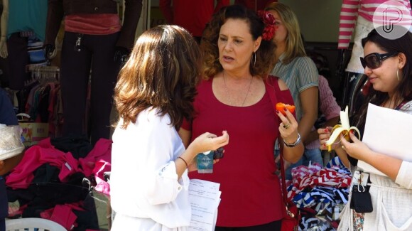 Enquando Márcia vende hot dog em cena, Elizabeth Savalla come caqui no intervalo das gravações de 'Amor à Vida'