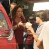 Elizabeth Savalla entrega o hot dog ao cliente da van de Márcia, sua personagem em 'Amor à Vida'