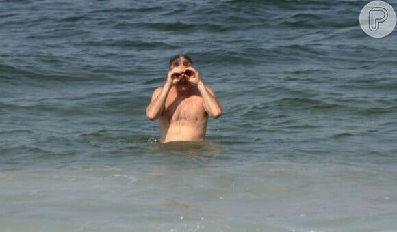 Pedro Bial percebe que está sendo fotógrafado em dia de praia no Rio