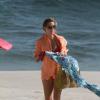 A atriz sacode a canga para ir embora da praia