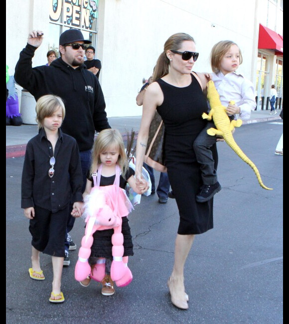 Aos 6 anos, ao lado da mãe, Angelina Jolie, e dos irmãos, Shiloh desfila de chinelo, bermudão e camisa de botão