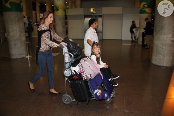 Ticiane Pinheiro leva a filha, Rafaella Justus, sentada sobre as malas