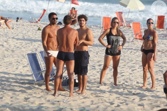 Caio Castro, no ar em 'Amor à Vida', conversa com amigos na praia da Barra da Tijuca, Zona Oeste do Rio de Janeiro