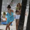 Alessandra Ambrósio e amiga seguiram para a areia enquanto bebiam água de coco. A top apostou em uma saída de praia azul clara