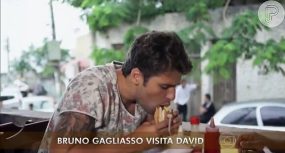 Na visita à comunidade, Bruno Gagliasso também atacou um sanduíche a pedido de David