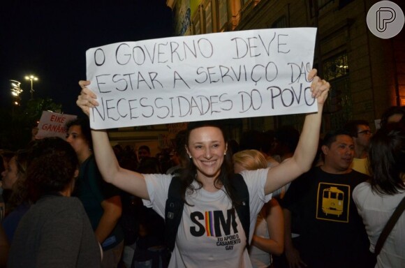 Paula Braum, mulher de Mateus Solano, mostra cartaz que levou para participar do protesto no Rio de Janeiro, em 20 de junho de 2013