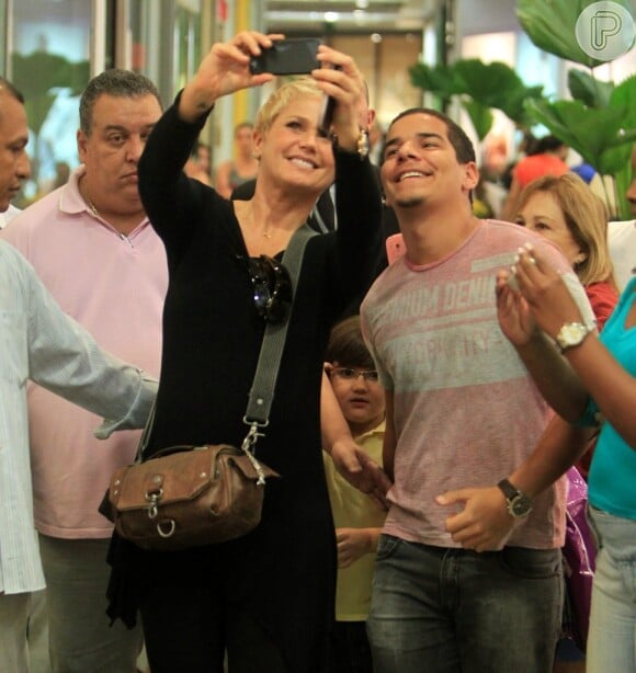 Xuxa pega o celular de um dos seus fãs para fazer a foto com ele