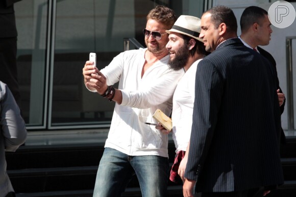 Simpático, Gerard Butler parou para tirar uma selfie com um dos fãs enquanto saía do seu hotel