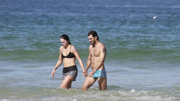 Juliano Cazarré se exercita e mergulha na praia ao lado da mulher, Letícia
