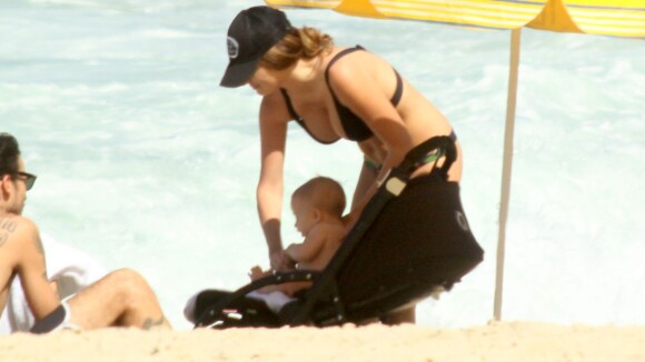 Erika Mader vai à praia com o marido e brinca com a filha em piscininha inflável
