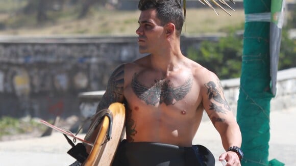 Juliano Cazarré exibe tatuagens de MC Merlô, de 'A Regra do Jogo', na praia