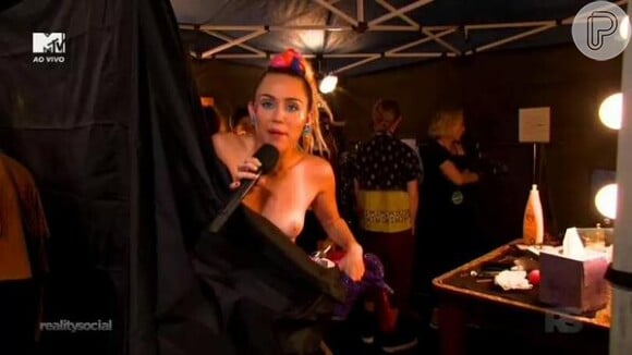 Polêmica e ousada, Miley Cyrus apresentou o VMA 2015 e aproveitou para saudar o público enquanto ainda estava se vestindo: 'Desculpem! Estou com as tetas de fora'